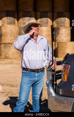 Farmer on cell phone near truck with antennas Stock Photo