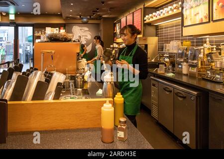 Starbucks barista making drinks, Kyoto, Japan Stock Photo