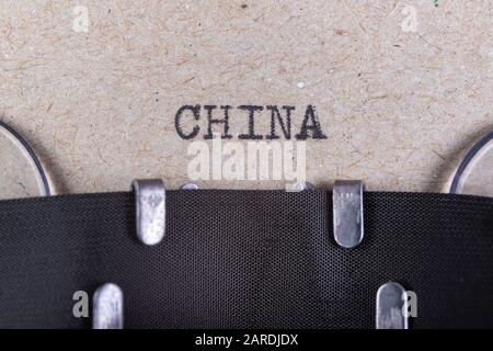 The word china written in typewriter font. The inscription in the old style on gray paper. Grey background. Stock Photo