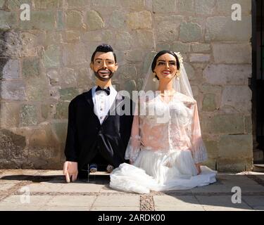 Giant puppets depicting the bride and groom prior to start of Traditional wedding parade (Calenda de Bodas) on the streets of Oaxaca. Stock Photo