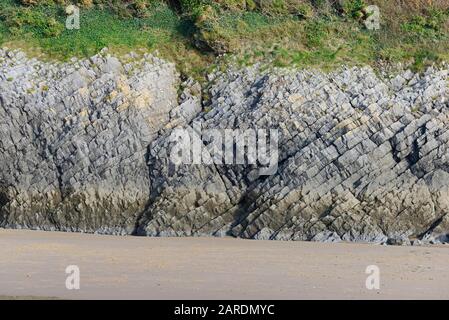 Carboniferous limestone rocks at Caswell Bay beach at Mumbles on the Gower peninsula, near Swansea, Wales, UK Stock Photo