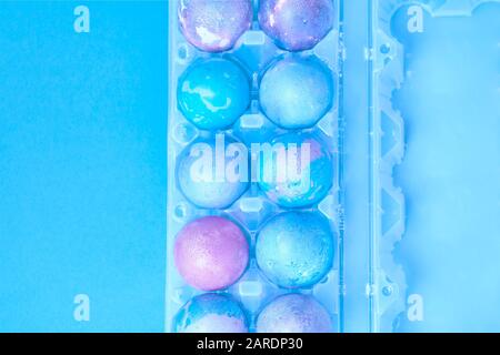 Painted Easter eggs with space intergalactic pattern in stand on blue background Stock Photo