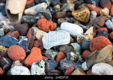 A sea glass bottle bottom amoung fragments of brick, chalk, and flint on the Thas foreshore, Greenwich, London. Stock Photo