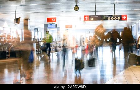 Airline Passengers in an International Airport inside a busy terminal. Stock Photo