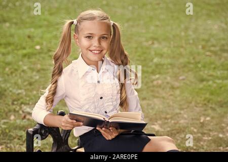 Study language. Cute smiling small child hold book. Adorable little girl school student. School education concept. Cute little bookworm. Knowledge day. Ready for lessons. Secondary school student. Stock Photo