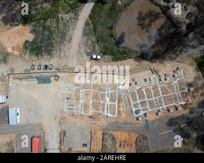 Subdivision homes and planned eco housing development aerial view with concrete formwork, trees and asphalt road in Victoria, Australia. Stock Photo