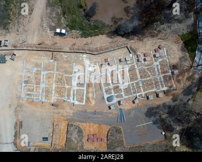 Subdivision homes and planned eco housing development aerial view with concrete formwork, trees and asphalt road in Victoria, Australia. Stock Photo