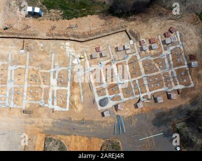 Subdivision homes and planned eco housing development aerial view with concrete formwork, trees and asphalt road in Victoria, Australia. Stock Photo