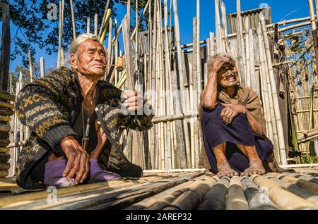 Apatani people in front of their house. Old men still wear the typical hair knot at their forehead, old ladies the noseplugs and tattoos Stock Photo