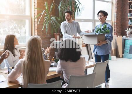 Young international team cheering asian guy newcomer Stock Photo
