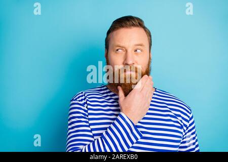 Portrait of minded pensive ginger hair beard man look copyspace think thoughts want solve work problems wear nautical vest isolated over blue color Stock Photo