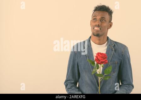 Young bearded African man wearing denim jacket against white background Stock Photo