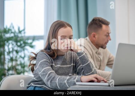 Long-haired girl in grey shirt looking serious Stock Photo