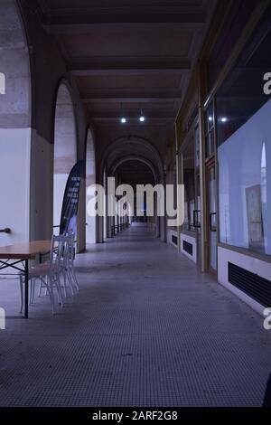 A table with chairs and a long passage Stock Photo