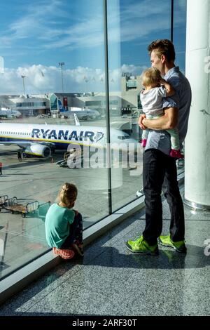 Family waiting at airport, man and kids watch planes on runway Airport Palma de Mallorca Ryanair plane Stock Photo