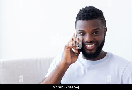 Smiling african american man talking by cellphone Stock Photo