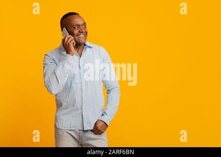 Positive mature afro man talking on cellphone Stock Photo