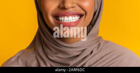 Closeup of perfect white smile of black muslim woman in headscarf Stock Photo