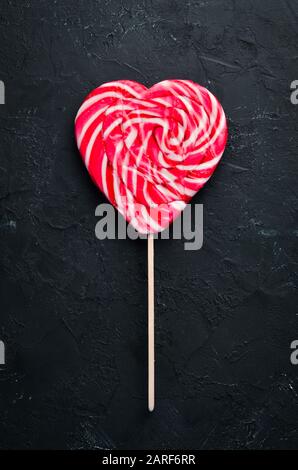 Candy on a stick in the form of a heart. Top view. free copying space. Stock Photo