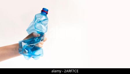 Female hand holding Crumpled or squashed plastic bottle Stock Photo