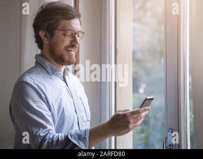 One guy checking cellular phone at home