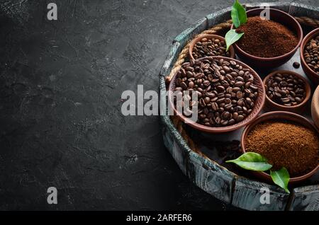 Ground coffee and coffee beans. Assortment of coffee varieties on a black background. Top view. Free space for your text. Stock Photo