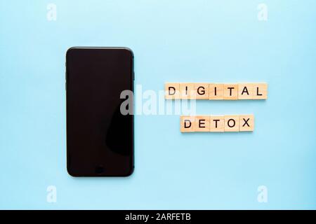 Smartphone and text digital detox on blue background. Social media addiction Stock Photo