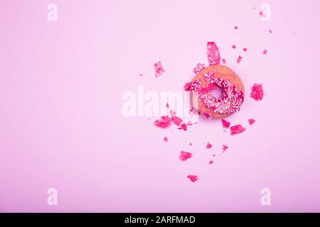 Broken donut on pastel pink background minimal creative concept. Stock Photo