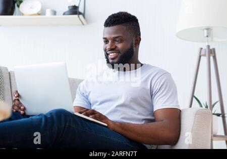 African soft developer programming code on laptop Stock Photo