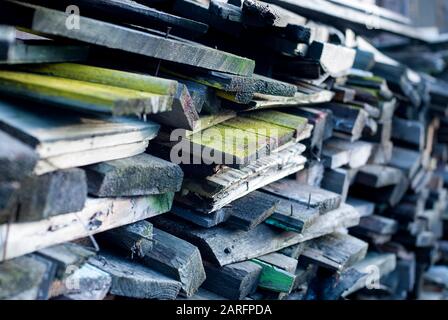 Stacked old boards of disassembled constructions will be used as firewood Stock Photo