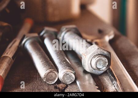 Tools for the job. Bolts and nut with wrench are on the table. Various carpentry tools. Stock Photo
