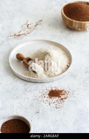 Teff flour on a plate with a spoon and teff grain in a bowl close up Stock Photo