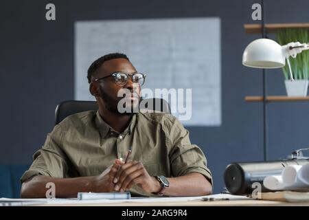Afro-American architect working in office with laptop.Business portrait of black handsome bearded man wearing eyeglasses sitting at workplace Stock Photo