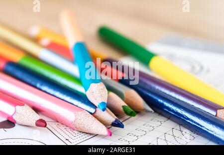 Colored pencils scattered on a school notebook. Close-up. Stock Photo