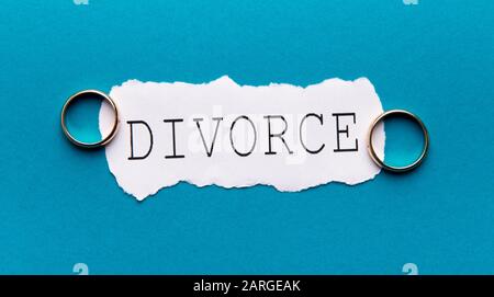 Word Divorce on paper sheet on the table with wedding rings Stock Photo