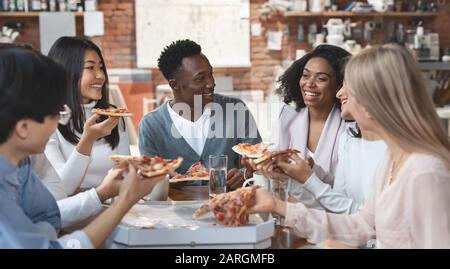 Multiracial colleagues eating pizza and having fun Stock Photo
