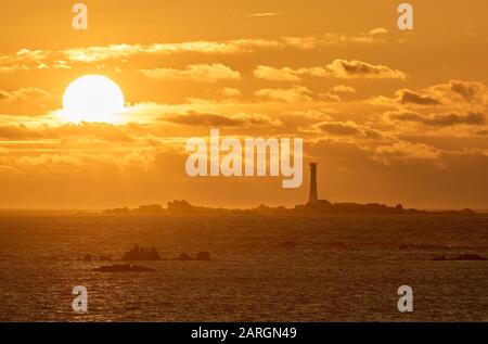 looking WSW from St Agnes towards the Bishop Rock Lighthouse on the Isles of Scilly at sunset Stock Photo