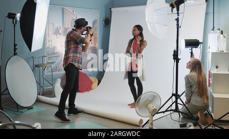 Photo session in modern studio: photographer taking photos of the black model an Stock Photo