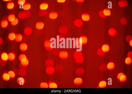 Red-orange trendy festive background of blurry Christmas lights Stock Photo