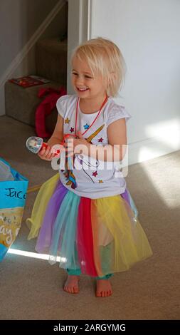 Three Year Girl Wearing Unicorn Fancy Dress Outfit Stock Photo