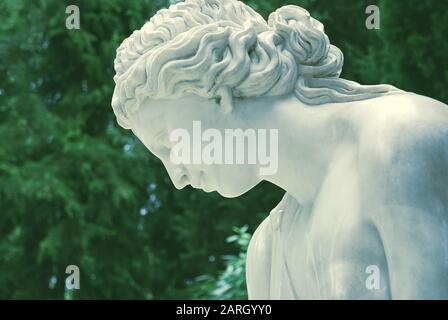 White classic marble sculpture of woman with bent head as symbol of grace and femininity Stock Photo