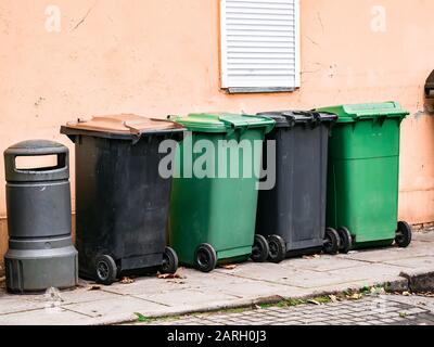 several garbage cans stand near the wall Stock Photo