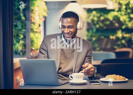 Portrait of black guy using computer listening to music Stock Photo