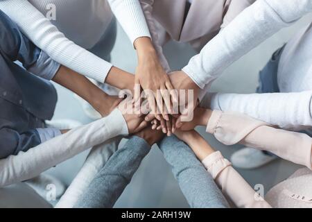 Multiracial business team putting hands on top of each other Stock Photo