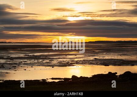 Dawn on the Northumbrian Coast, looking across the tidal mudflats towards Bamburgh Castle England, UK, GB. Stock Photo