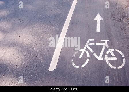 Bicycle icon on asphalt road Stock Photo