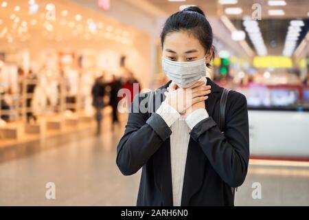 Alarmed female traveler wears medical mask protect Stock Photo