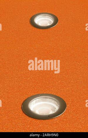 Recessed circular floor lamp in a rusty metal plate or pavement. Stock Photo