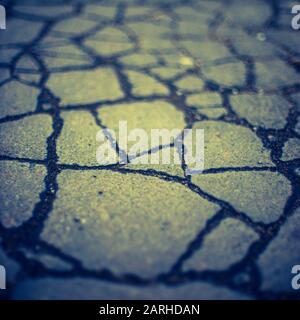 Old asphalt road surface in cracks. Stone texture Stock Photo