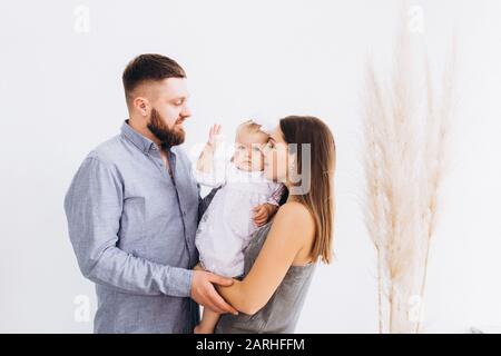 Happy young family in a bright studio. Full family. Stock Photo